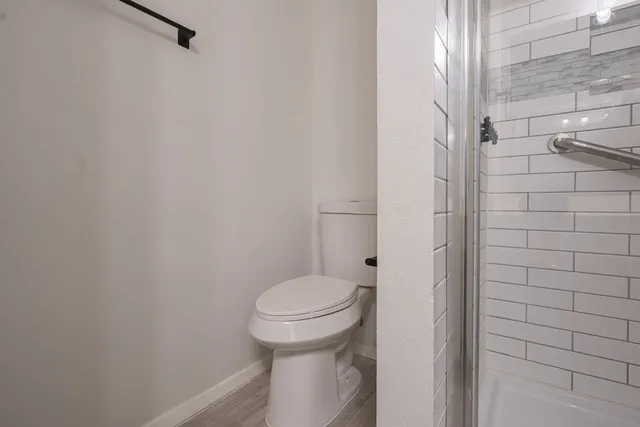 a bathroom with a toilet and a shower