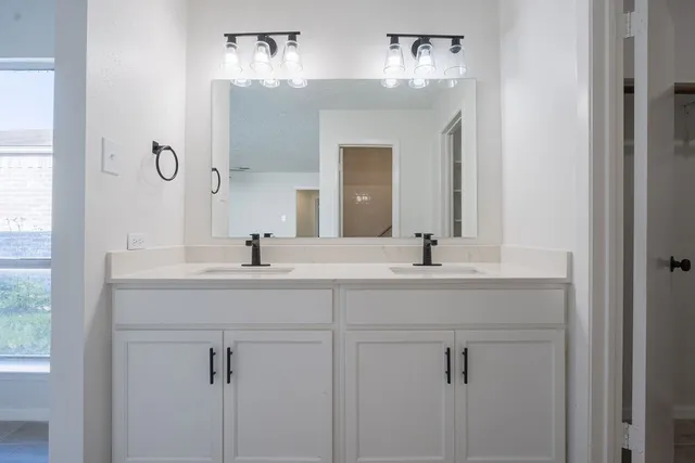 a bathroom with a double vanity sink mirror and