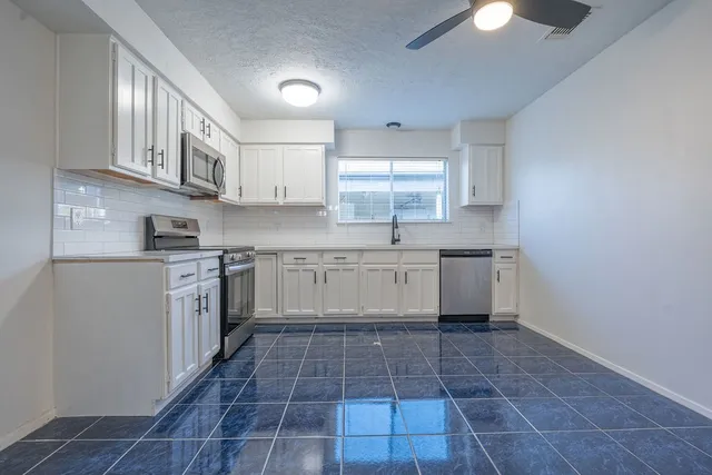 a kitchen with a stove sink and cabinets