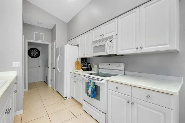 a living room with furniture and a large window with kitchen view