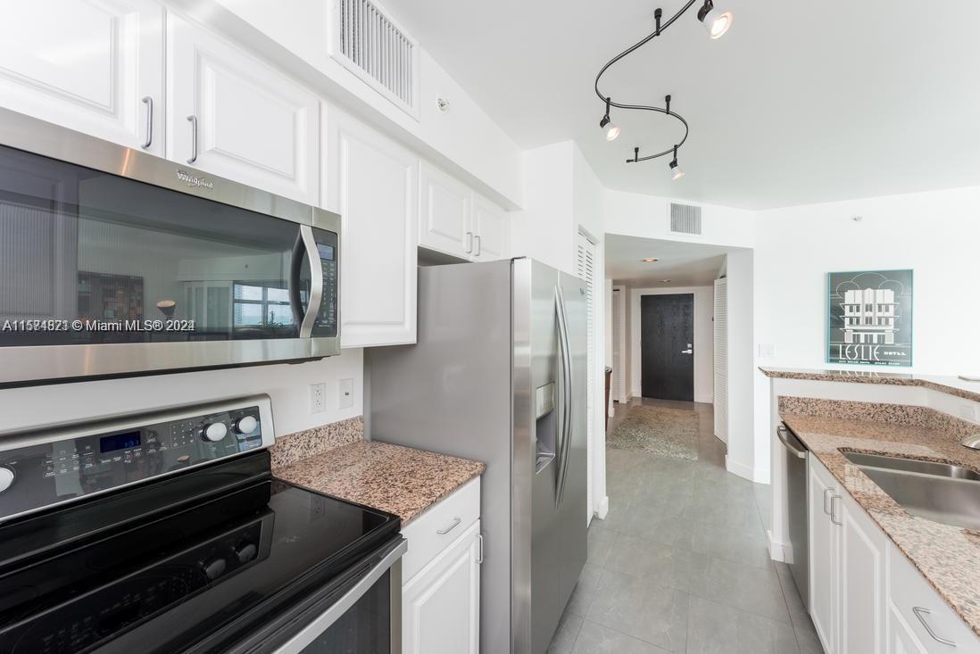 90 Alton Road, Unit 1502 Miami Beach, FL 33139 - Photo 19 of 29 a kitchen with stainless steel appliances granite countertop a stove and a refrigerator