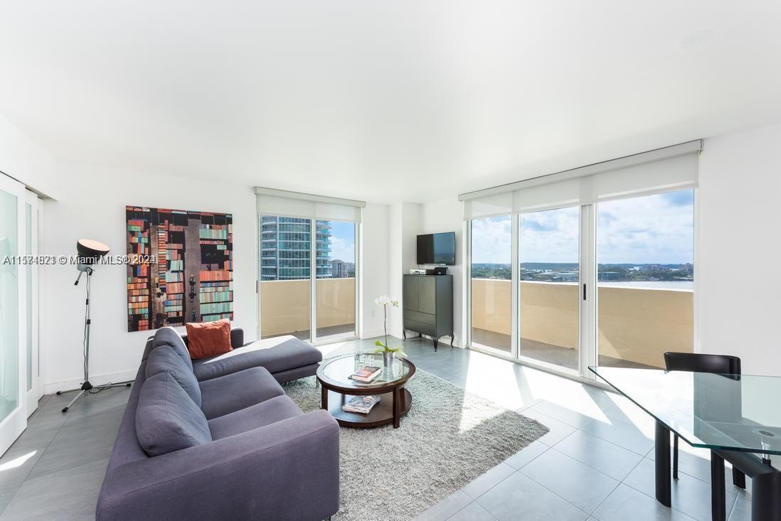 90 Alton Road, Unit 1502 Miami Beach, FL 33139 - Photo 2 of 29 a living room with furniture and a large window