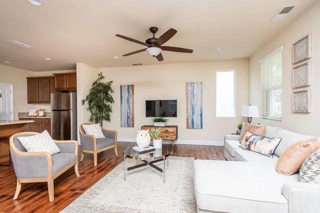 a living room with furniture a large window and a flat screen tv