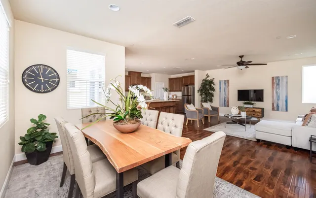 a kitchen with stainless steel appliances kitchen island granite countertop a stove a sink a refrigerator and white cabinets with wooden floor