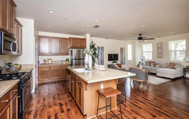a kitchen with stainless steel appliances granite countertop a stove a sink and a refrigerator