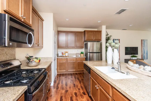 a open kitchen with stainless steel appliances granite countertop a lot of counter space and wooden floors