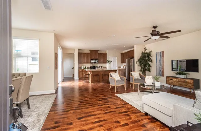 a living room with stainless steel appliances furniture and a flat screen tv