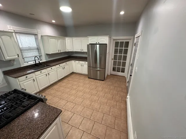 a kitchen with stainless steel appliances granite countertop a refrigerator and a sink