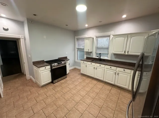 a kitchen with granite countertop a sink and cabinets