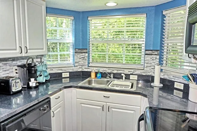 a kitchen with sink a window and cabinets