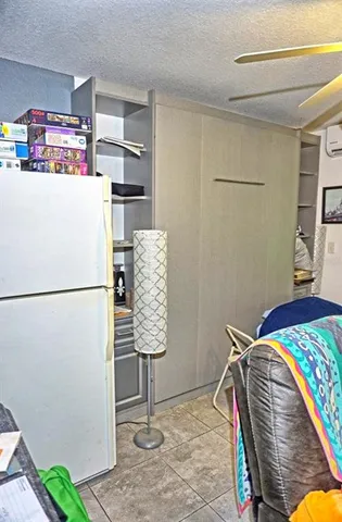 a bedroom with a bed and a refrigerator