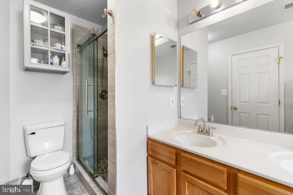 a bathroom with a sink toilet double vanity and shower