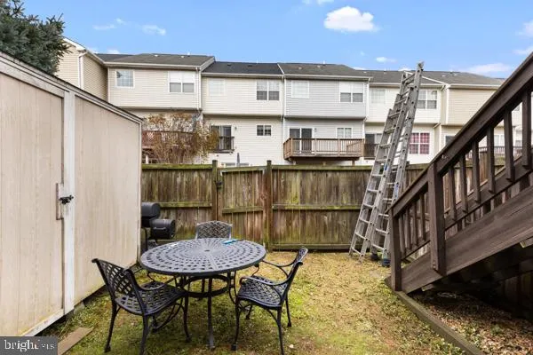 a view of a chairs and table on the deck in front of house