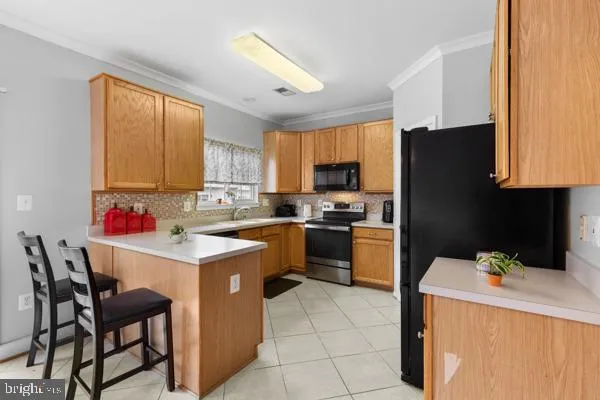 a kitchen with a refrigerator a stove a sink dishwasher and wooden cabinets