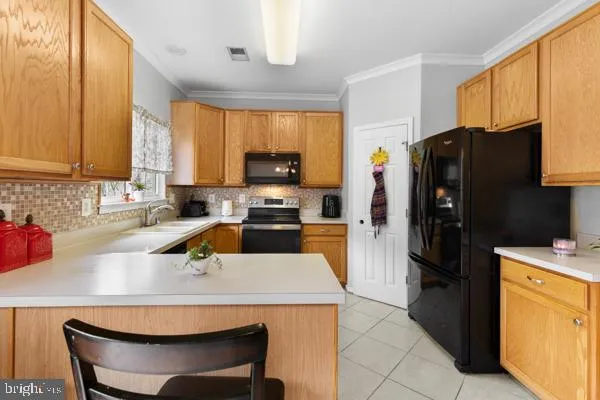 a kitchen with a refrigerator a stove a sink a counter top space and cabinets