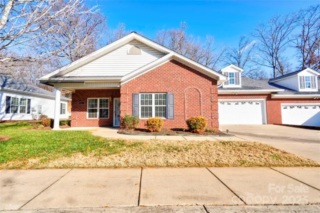 a front view of a house with a yard and potted plants