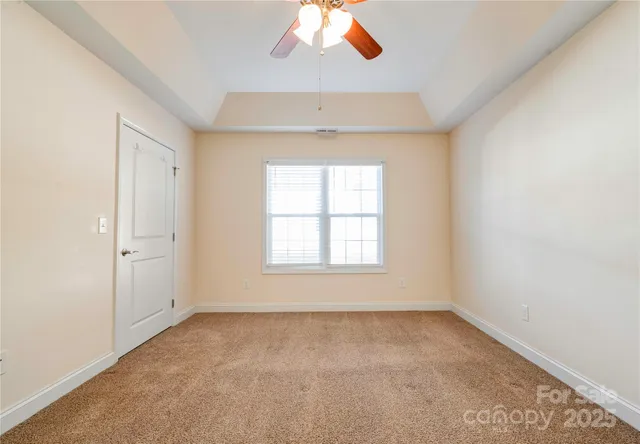an empty room with a window and a ceiling fan