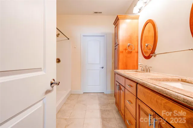 a spacious bathroom with a granite countertop sink and a mirror