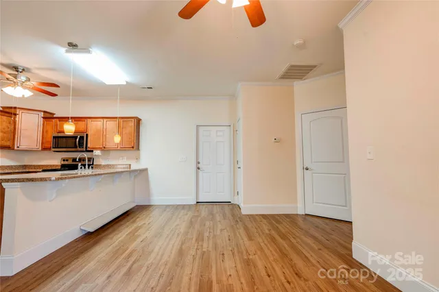 a view of a kitchen with wooden floor and electronic appliances
