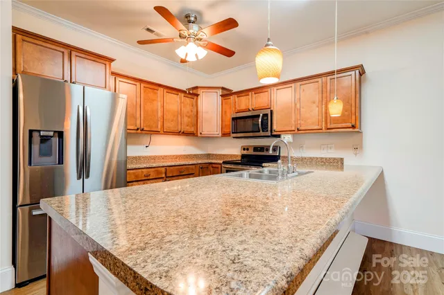 a kitchen with stainless steel appliances granite countertop a sink a stove and a refrigerator