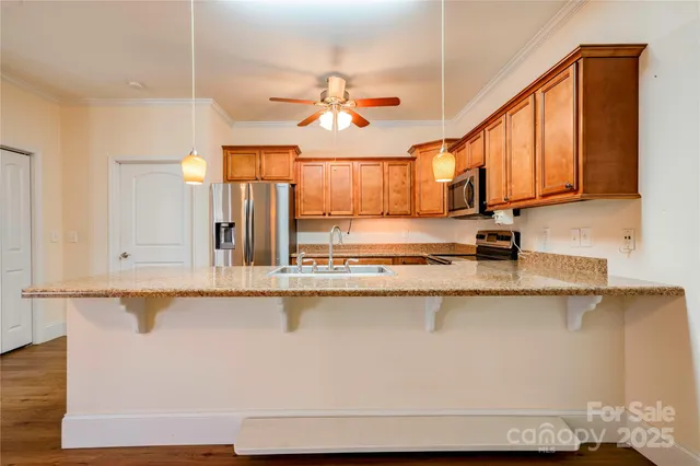a kitchen with stainless steel appliances granite countertop a sink a stove and cabinets