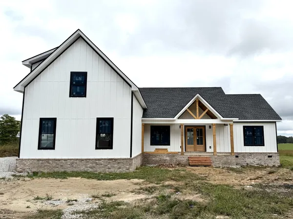 a view of a yard in front of a house with a large tree