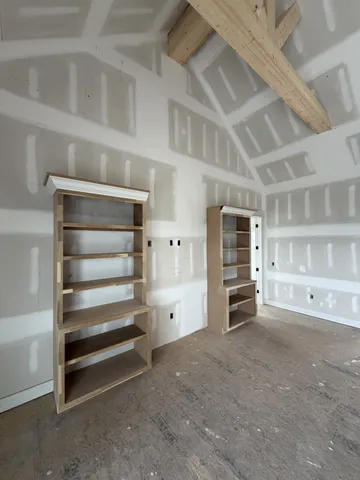 a view of an empty room with cabinet and a window