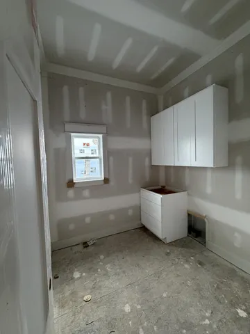 a view of an empty room with a fireplace and a window