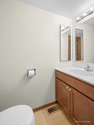 a bathroom with a sink mirror vanity and toilet