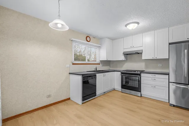 a kitchen with stainless steel appliances granite countertop a stove a sink and a refrigerator