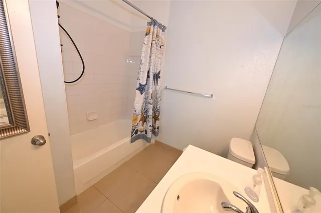 a bathroom with a sink and mirror with toilet