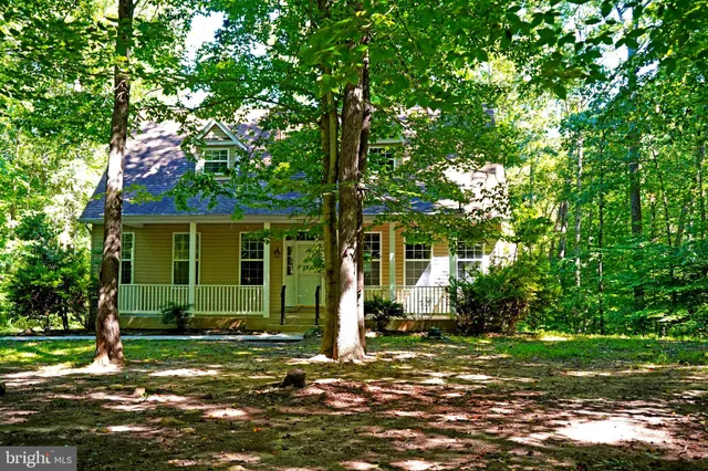 a front view of a house with a tree in a yard