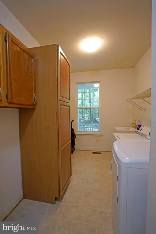 a utility room with cabinets washer and dryer