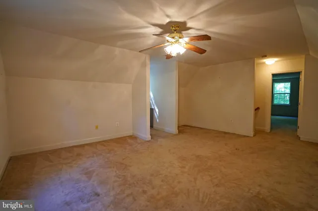 a view of an empty room with a chandelier fan