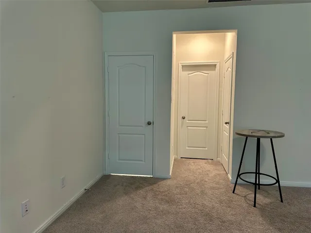 an empty room with closet and a hallway