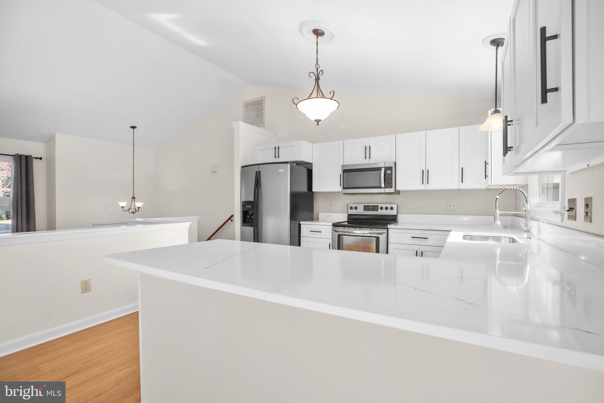 8 Rutledge Cove Ruther Glen, VA 22546 - Photo 11 of 46 a kitchen with kitchen island a sink stainless steel appliances and white cabinets