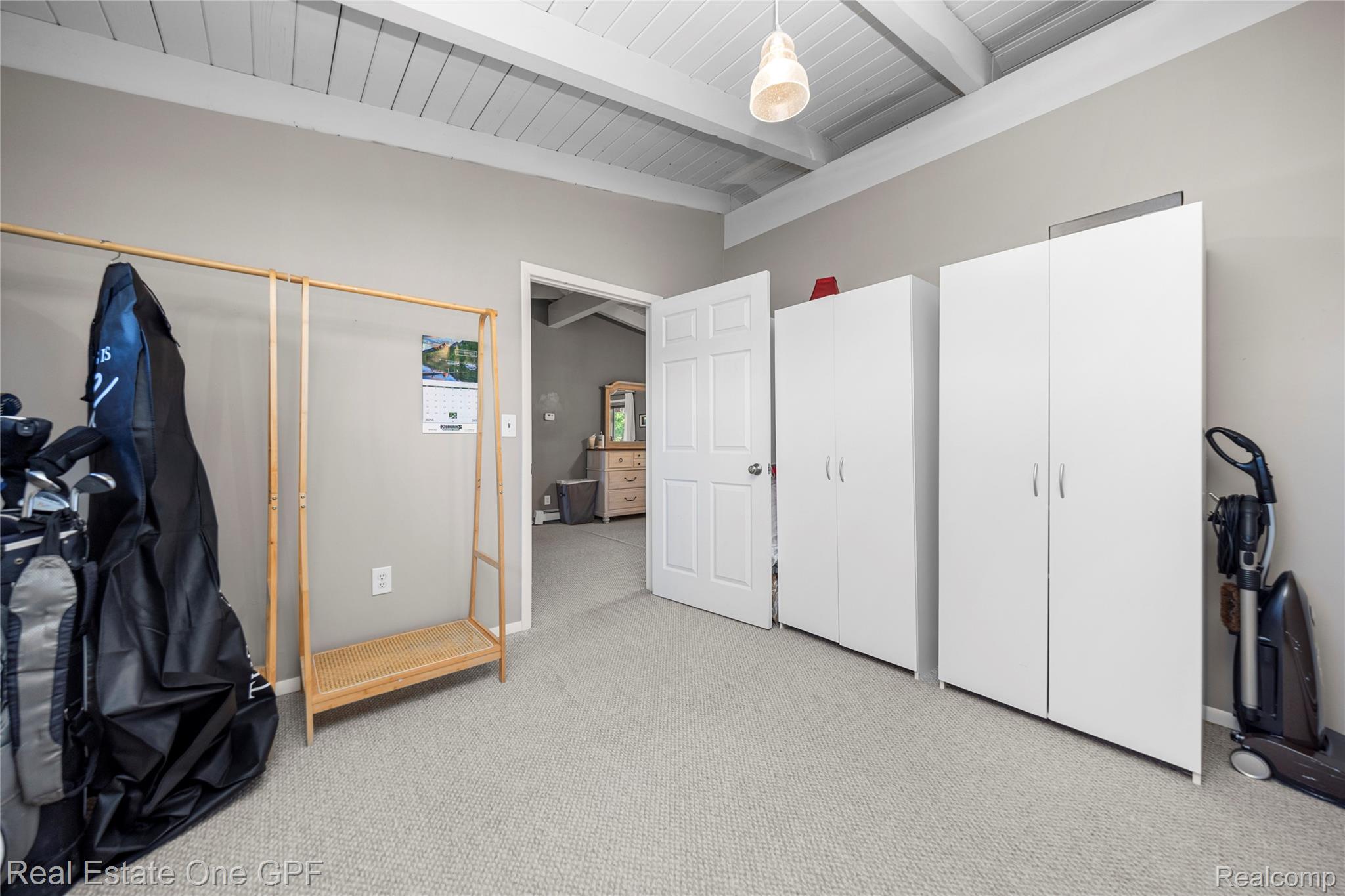 5068 Atkins Road North Street, MI 48049 - Photo 32 of 78 Vaulted wood-beam ceiling, neutral tone carpeting, white paneled door, and two white storage cabinets