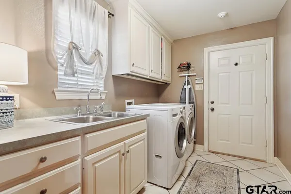 a utility room with cabinets washer and dryer