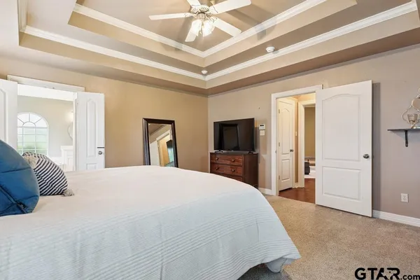 a bedroom with a large bed and a tv