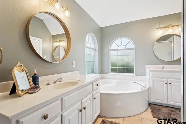 a bathroom with a tub sink and mirror