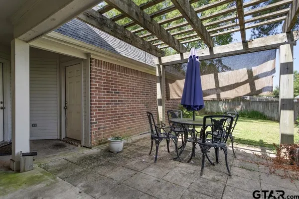 a view of a patio with a table and chairs and potted plants