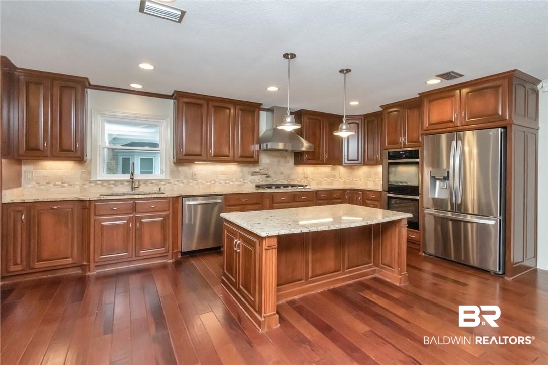 6109 Timberly Road North Mobile, AL 36609 - Photo 2 of 26 Kitchen with pendant lighting, sink, appliances with stainless steel finishes, a center island, and dark hardwood / wood-style flooring