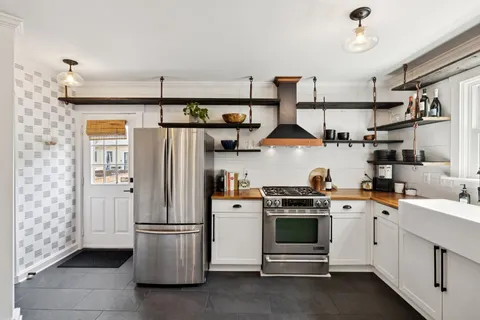 a kitchen with a refrigerator and white cabinets