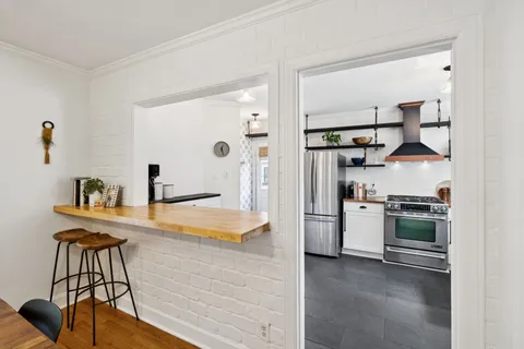 a kitchen with stainless steel appliances a sink stove and white cabinets