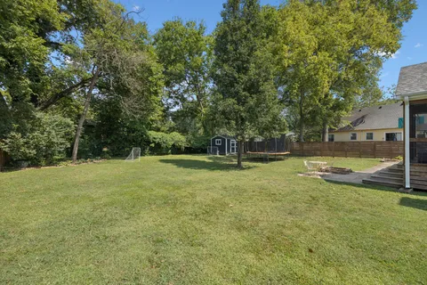an aerial view of residential house with outdoor space and trees all around