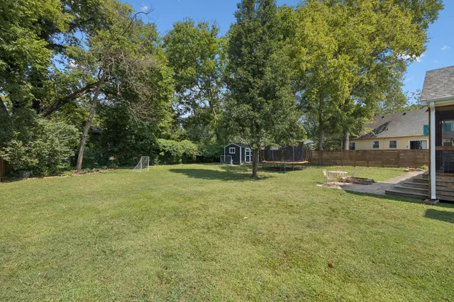 an aerial view of residential house with outdoor space and trees all around