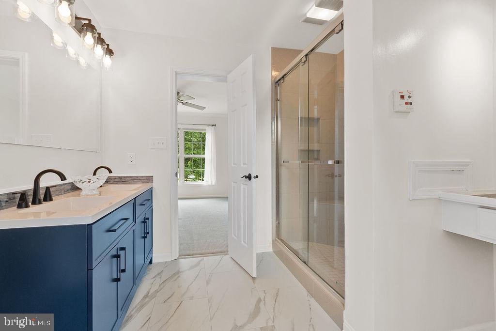 19821 Foggy Bottom Road Bluemont, VA 20135 - Photo 84 of 92 a bathroom with a double vanity sink a mirror and a shower