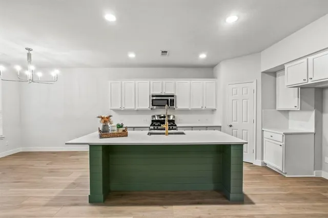 a kitchen with kitchen island a sink stainless steel appliances and cabinets