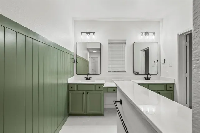 a spacious bathroom with double vanity and a mirror