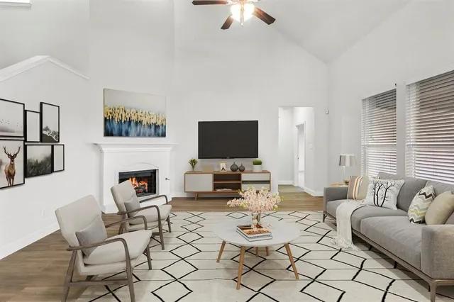 a living room with furniture a flat screen tv and a fireplace